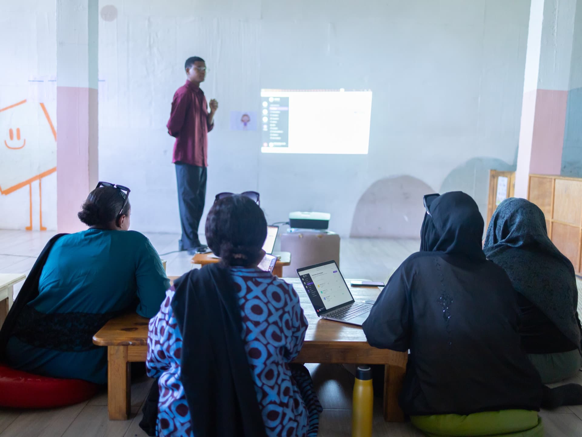Un membre de l’équipe Cschool présente la plateforme à l’équipe de HOPE School of Life, ordinateurs ouverts
